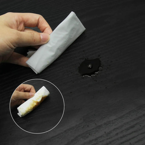 Black Wood Grain Removable Peel And Stick Wallpaper Roll resisting water and stains shown with a cleaning wipe on surface