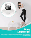 12 Inch Motorized Rotating Turntable Display Stand With 360 Degree Spin For Product Photography shows a woman photographing a kettlebell.