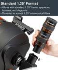Boost Your Backyard Stargazing Game With A 3X Barlow Lens For 1.25 Inch Eyepieces Fully Multi Coated Apochromatic Optics Ultra Clean Optics Black Housing Expands Magnification For Fast Telescopes And Night Sky Exploration showing a person holding a black and orange Barlow lens next to a telescope.