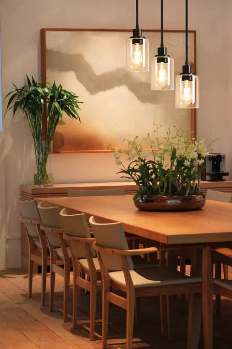Industrial Three Light Pendant Light With Adjustable Height Up To 34 Inches, Black Finish And Clear Glass Shade in dining room setting