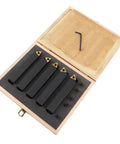 Open wooden box with five black carbide turning tools featuring gold inserts and a hex key