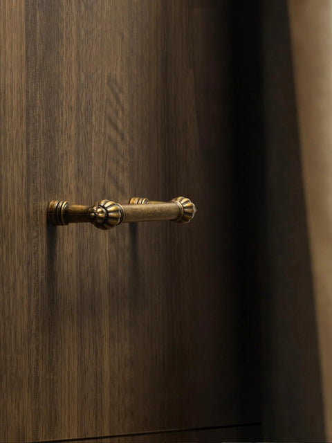 Antique Brass Zinc Alloy Cabinet Pulls Three And Three Quarters Inch Hole Center Classic Vintage Drawer Handles on wood surface