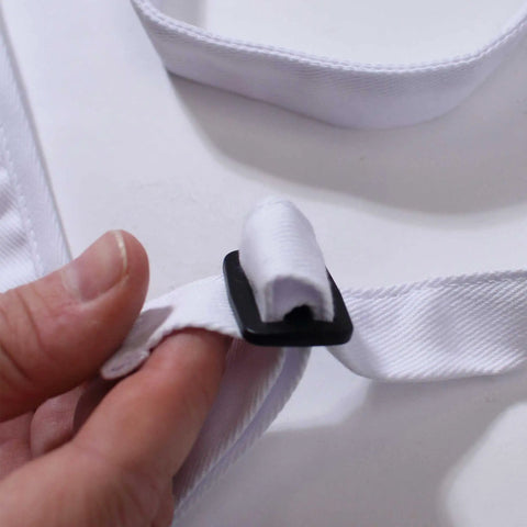 Close-up of adjustable neck strap on The Office Inspired Kevin's Famous Chili Cook-Off Fan Favorite Apron in 100% white cotton.