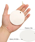 Close-up of hand holding a 40 Pieces Sublimation Ceramic Ornaments Blanks With Holes 2.95 Inch Round White Porcelain Disc
