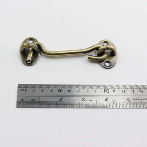 Stainless Steel Hook And Eye Latch 4.72 Inch Gate Latch Privacy Lock with ruler for scale in antique bronze finish.