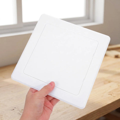 Hand holding a White Peel And Stick Ceiling Access Panel Self Adhesive Pipe Cover for easy installation and concealment.
