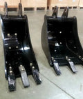 Two black buckets for BH6600HT Beefy Heavy Duty 3 Point Hitch Backhoe 7 ft digging depth with removable teeth on a warehouse floor.