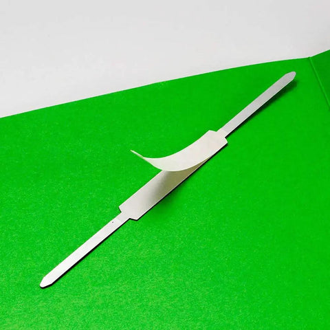 Self Adhesive Prong Paper Fasteners With A Classic Matte Steel Finish That Nails Down Bulk Paperwork And Bulletin Boards Delivering Zero Fluff Organization And A Trustworthy Grip For Daily Office Grind Without The Hassle, displayed on green background.