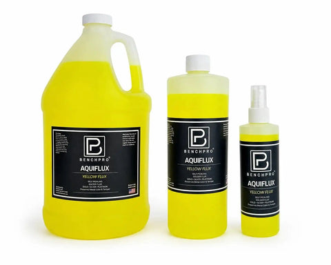 Three bottles of Benchpro Aquiflux yellow flux for metalwork, featuring various sizes for jewelry making and welding processes.