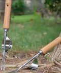 Back-Saving Garden Weeding Tool With Wood Handle And Stainless Steel Forks near tree for Quick Weeding Leverage Design