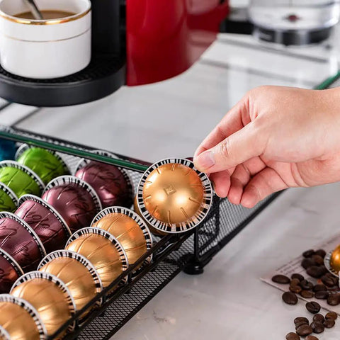 Hand holding pod from Neat And Tidy 50 Pod Vertuo Capsule Holder With Crystal Tempered Glass Top For Nespresso Vertuo Pods Storage Organizer