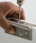 Hand drilling into wood with Heavy Duty L Bracket Set 8 Pack For Furniture And Cabinets 90 Degree Stainless Steel Corner Braces.