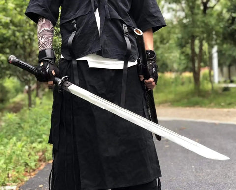 Man holding hand forged Longquan style dao sword with high carbon steel blade full tang and dope matte black wooden scabbard