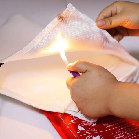 Hands holding a Must Have Fire Blanket Kit For Home And Kitchen Two Pack Grab And Go 3.3 By 3.3 Feet Fiberglass Flame Retardant Safety Gear.