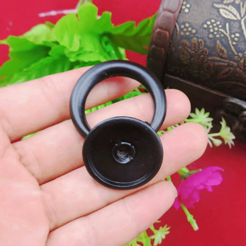 Close-up of a black Four Pack Vintage Ring Drawer Pulls For Dresser Cupboard Doors in zinc alloy, held in hand.
