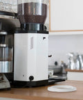 Premium Silicone Grouphead Gasket Replacement For Breville Casabrews Espresso Machines And More, shown next to a coffee grinder.