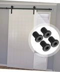 Four Pack Replacement Carbon Steel Track Spacers Set For Barn Doors And Sliding Door Hardware Heavy Duty Connector Spacers To Fix Tracks To Wall Ideal For Garage Basement Farmhouse Doors And Wall Mount Tracks showing black spacers in front of a white barn door installation.