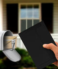 Hand holding black envelope from Trading Card Shipping Kit 400 Pcs Envelopes And Rigid Self Seal Mailers 4x6 For TCG And Sports Cards