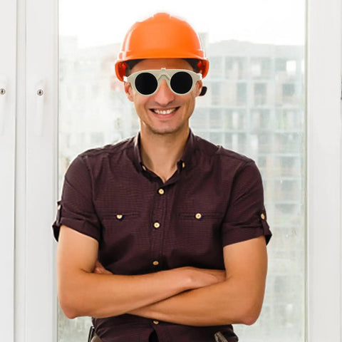 Man wearing orange helmet and built tough welding glasses, posing with arms crossed, showcasing ergonomic fit and eye safety.