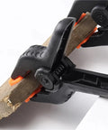 Close-up of a four inch durable plastic nylon spring clamp holding a wooden piece, Must Have Four Inch Spring Clamps Set For Woodworking And Photo Studio Backdrops Durable Plastic Nylon Clips For Furniture Accessories Space Saving Desk Organizer To Keep Papers Notes And Gear Neat.