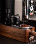 Universal 58mm Espresso Coffee Distributor With Gravity Tumbler For Standard Portafilters on wooden base with ground coffee.
