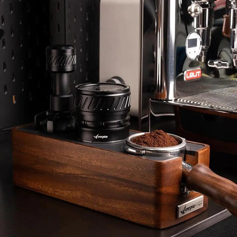 Universal 58mm Espresso Coffee Distributor With Gravity Tumbler For Standard Portafilters on wooden base with ground coffee.