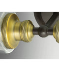 Close-up view of Two Light Clear Glass Farmhouse Bath Vanity Light in Antique Bronze Finish with warm ambient lighting details.