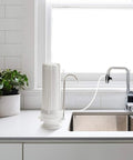 Slick Countertop Water Filter With Fluoride Arsenic Chlorine Reduction No Sweat Compact 3 Stage Filtration System For Pure Drinking Water Made In Usa, installed on a kitchen counter.