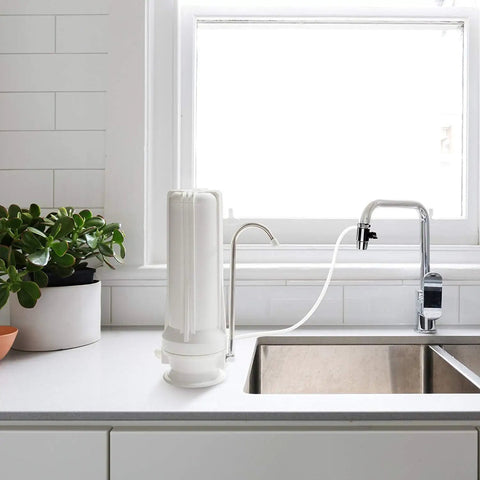 Slick Countertop Water Filter With Fluoride Arsenic Chlorine Reduction No Sweat Compact 3 Stage Filtration System For Pure Drinking Water Made In Usa, installed on a kitchen counter.