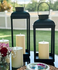 Huge Outdoor Solar Powered LED Candle Lantern 18 Inch Tall Open Frame Black Metal Dusk To Dawn Auto On Timer No Glass Porch Garden Patio Decor Weatherproof placed on a table.