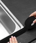 Top Tier Black Caulk Strip For Kitchen Countertops And Sink Backsplash Waterproof Seal Tape With Serious Strong Adhesion being applied on countertop edge.