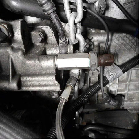 Installed stainless steel 1/8 NPT oil pressure sensor tee adapter on engine with sensor connector and hoses