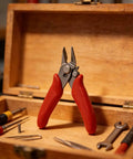 Top Shelf Heavy Duty Screw Cutter Tool With Razor Sharp Flush Blades And Ergonomic Red Rubberized Grips on wooden toolbox.