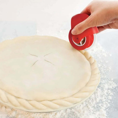 Pastry wheel dough cutter with red handle used to crimp pie crust edge, front view.