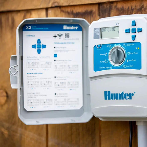 14-Station Outdoor Sprinkler Controller with Wi-Fi Smart Irrigation System Hydrawise Compatible Weather Based Scheduling for Lawn and Garden, Remote Management from Smartphone or Desktop shown installed on wooden wall