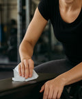 Person using EPA Registered Antibacterial Wipes For Surfaces And Equipment That Kill 99.9 Percent Of Germs In 15 Seconds, Effective Against H1N1 MRSA Flu Strep E Coli Salmonella HIV 1 VISA VRE, 3,200 Count, 4 Rolls on a gym bench