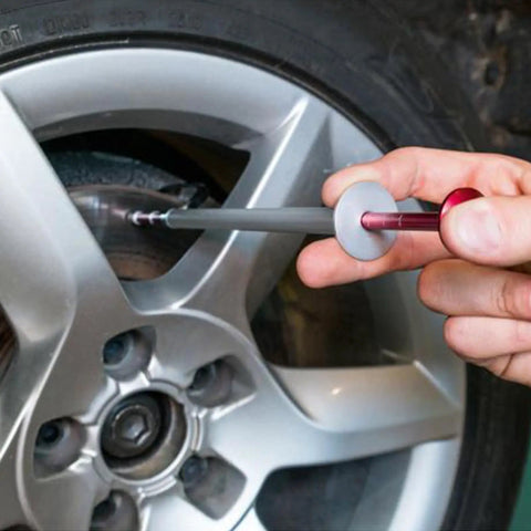 Person using Brake Disc Thickness Measurement Verniers Caliper on car tire, measuring brake thickness accurately.