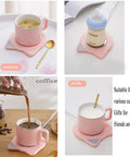 Keep Your Daily Grind Toasty With This Rapid Heating Desk Coffee Warmer Featuring Smart Temperature Controls Dual Timer Auto Shutoff And An Anti Slip Plate For Zero Mess Sipping, pink mug with scented tea and milk.