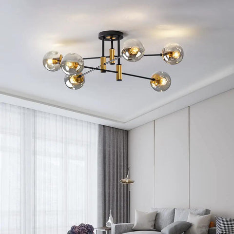 Six Light Sputnik Glass Globe Chandelier in black and gold hanging in modern living room with mid-century design.