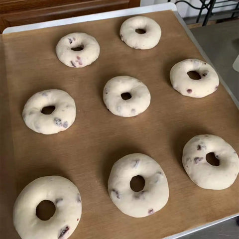 Heavy Duty PTFE Dehydrator Sheets 14 Inch Nonstick Baking Mats And Oven Liners For BBQ Hot Plate Reusable Heat Resistant Food Safe Kitchen Gear That Makes Prep A Cinch with raw bagels on top.