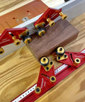 Pro Grade Portable Aluminum Table Saw Roller Feeder Dolly Featuring Smooth Ball Bearings For No Sweat Wide Lumber Pushing And Rock Solid Woodworking Safety Assist Stand with red aluminum rollers and wooden block.