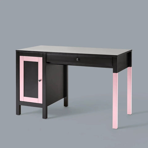 Black desk with pink accents and a single drawer, featuring a cabinet and rectangular tabletop on a gray background.