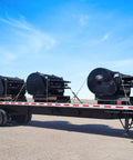 Flatbed trailer transporting three large industrial machines in a desert setting, secured with Four Pack Three Eighth Inch Grade 70 Binder Chain.