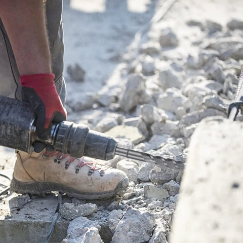 Person using SDS Max Masonry Drill Bit Set With Carbide Tips, 5 Piece, for drilling concrete, shown in action with rotary hammer.