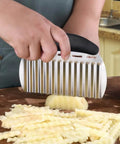 NULIZL stainless steel crinkle cutter with black handle slicing a potato into crinkle-cut fries on a wooden board