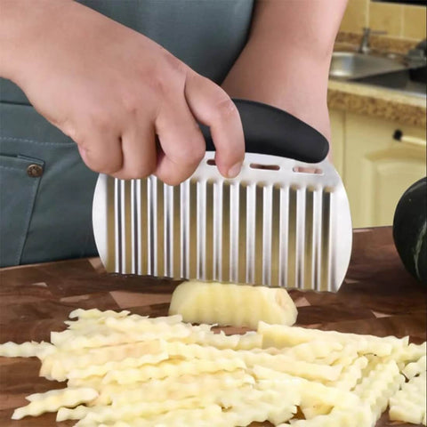 NULIZL stainless steel crinkle cutter with black handle slicing a potato into crinkle-cut fries on a wooden board