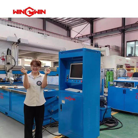 Blue WingWin waterjet flow intensifier pump unit with touchscreen display in a factory setting.