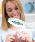 Woman using LED Bifocal Magnifying Lamp With 1,200 Lumens, Dual 2.25X And 6X Magnification, 5 Inch Glass Lens for knitting