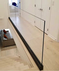 Heavy Duty Glass Railing System For Deck And Balcony Featuring Rock Solid Spigot Clamps With Flexible Floor Or Side Mount Hardware And Premium Aluminum Posts In Matte Black Covers for indoor staircase.