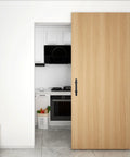 Sliding Barn Door Pull Handle Set With Flush Hardware In Rustic Black Powder Coat Finish on a wooden interior door